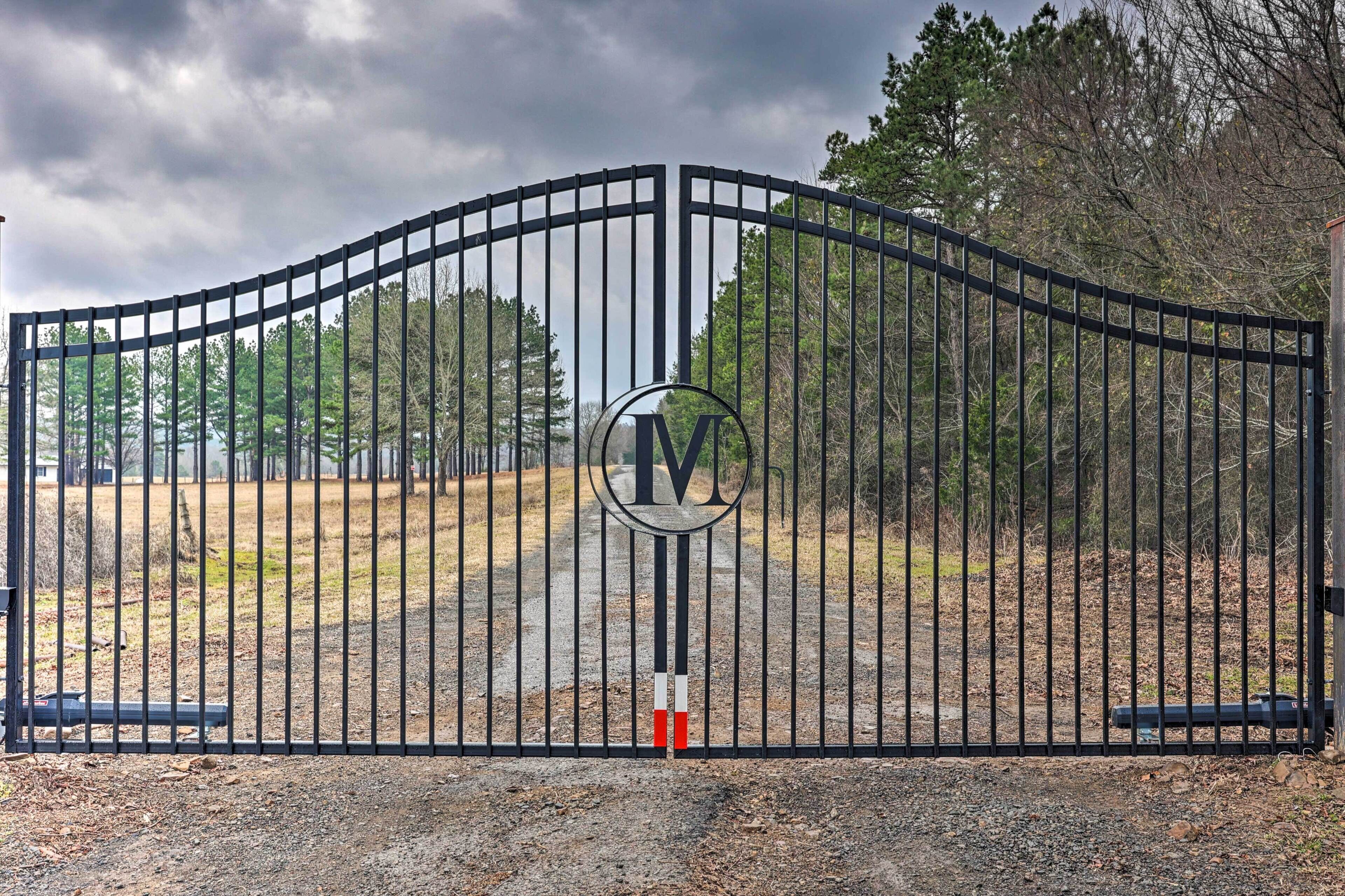 A gated entrance with a metal gate and a circular logo.