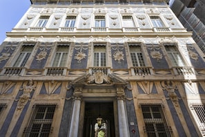 A historic building with ornate architectural details, including columns, decorative moldings, and statues. - Garibaldi Attic by Wonderful Italy (Genoa)