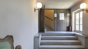 A staircase with a metal railing and a wall-mounted light fixture. - Garibaldi Attic by Wonderful Italy (Genoa)
