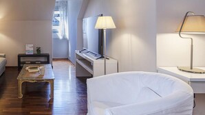 A modern bedroom with a white bed, a small desk, a lamp, and a view of the outside. - Garibaldi Attic by Wonderful Italy (Genoa)