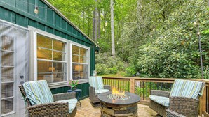A deck with wicker furniture and a stone fire pit. - Highlands Vacation Rental - Walk to Main St! (Highlands)