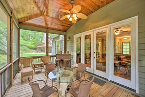A covered porch with wicker furniture, a glass table, and a ceiling fan. - Townville Lakefront Cottage w/ Private Dock! (Townville)