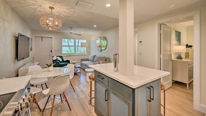 A modern kitchen with a marble countertop, stainless steel appliances, and a pendant light. - Luxe Naples Escape: Walk to Beach & Downtown! (Naples)