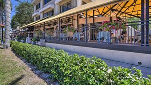 A hotel with outdoor seating, a covered patio, and a well-maintained garden. - Luxe Naples Escape: Walk to Beach & Downtown! (Naples)