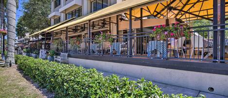 Een hotel met terras, overdekte patio en een verzorgde tuin.