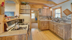 A kitchen with wooden cabinets, a gas stove, and a countertop. - Palmyra Cottage w/ Deck on Whites Pond! (Palmyra)