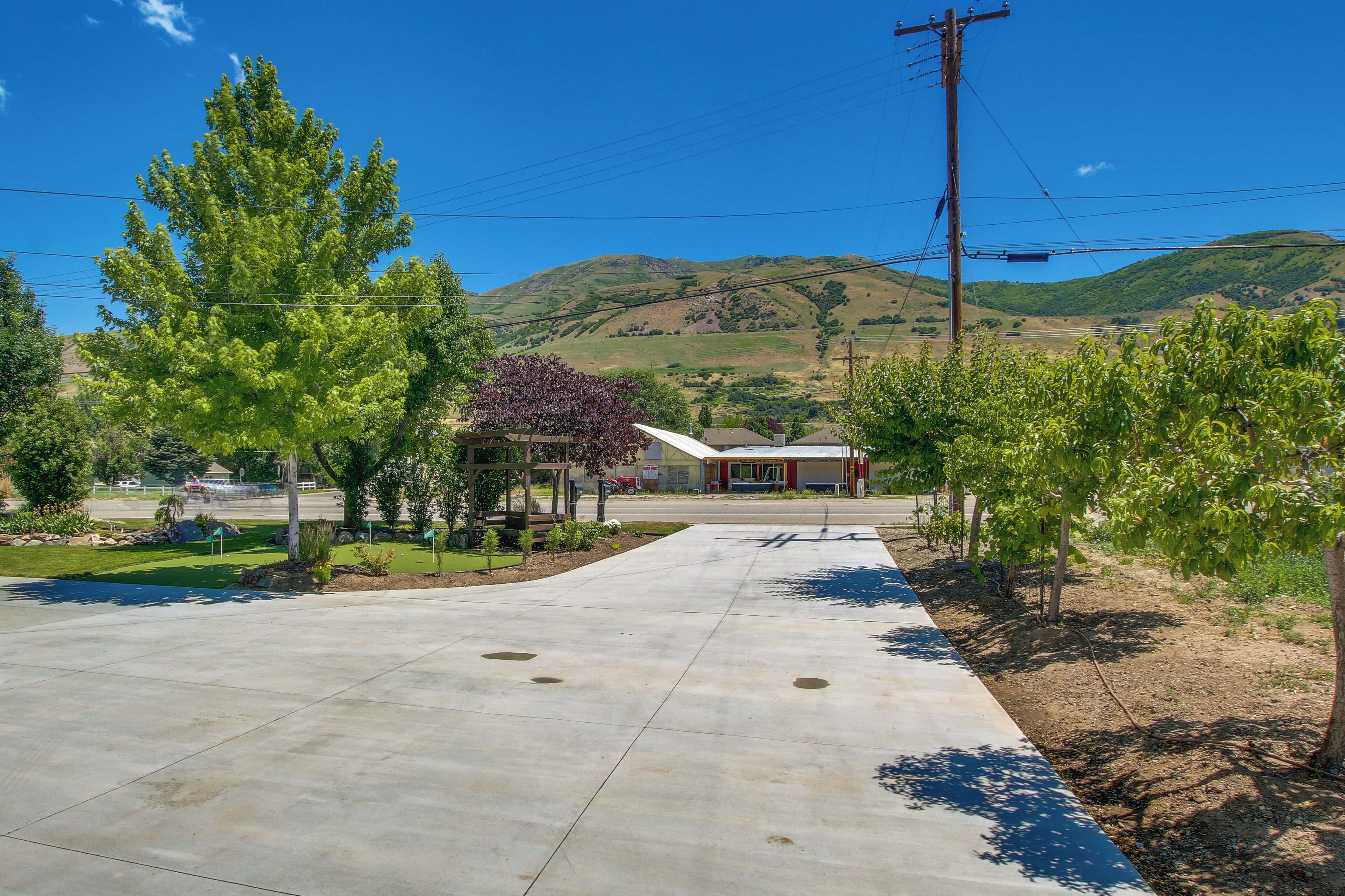 A paved driveway leading to a building with a gas station in the background.