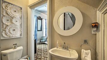 A bathroom with a toilet, sink, and mirror.