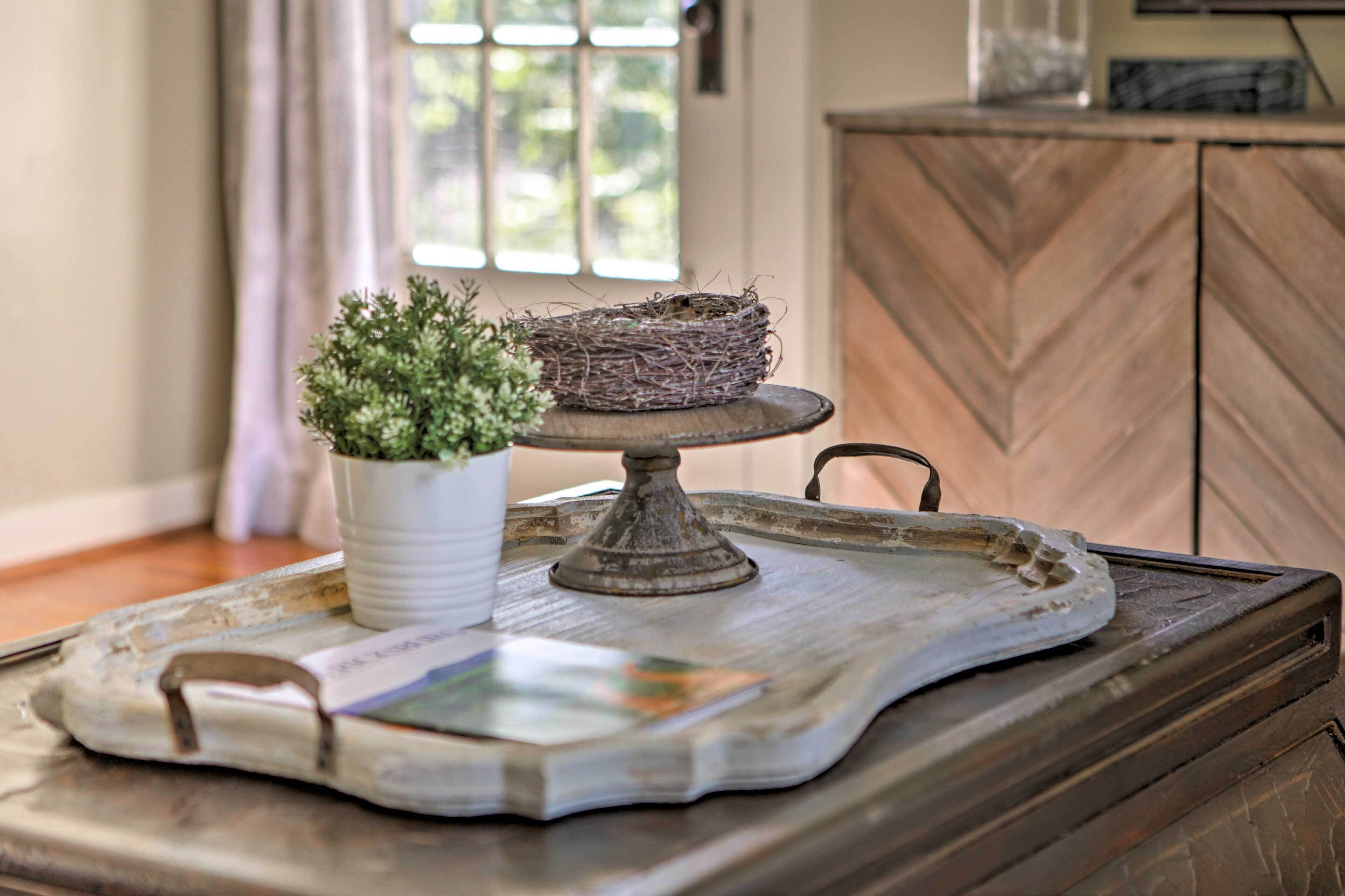 A tray with a potted plant and a bird's nest on a wooden table.