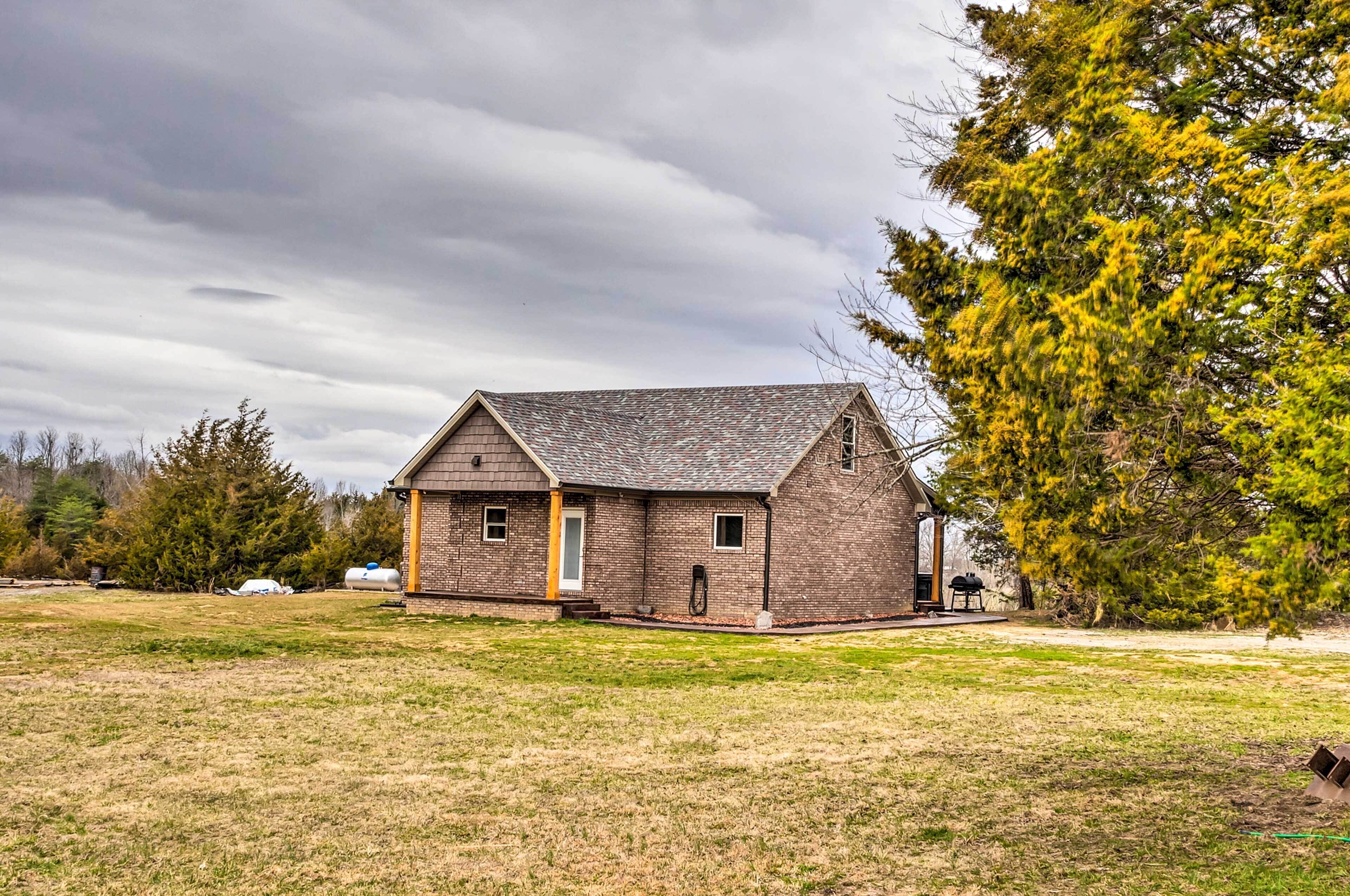 A single-story brick building with a gabled roof, a small porch, and a visible chimney.