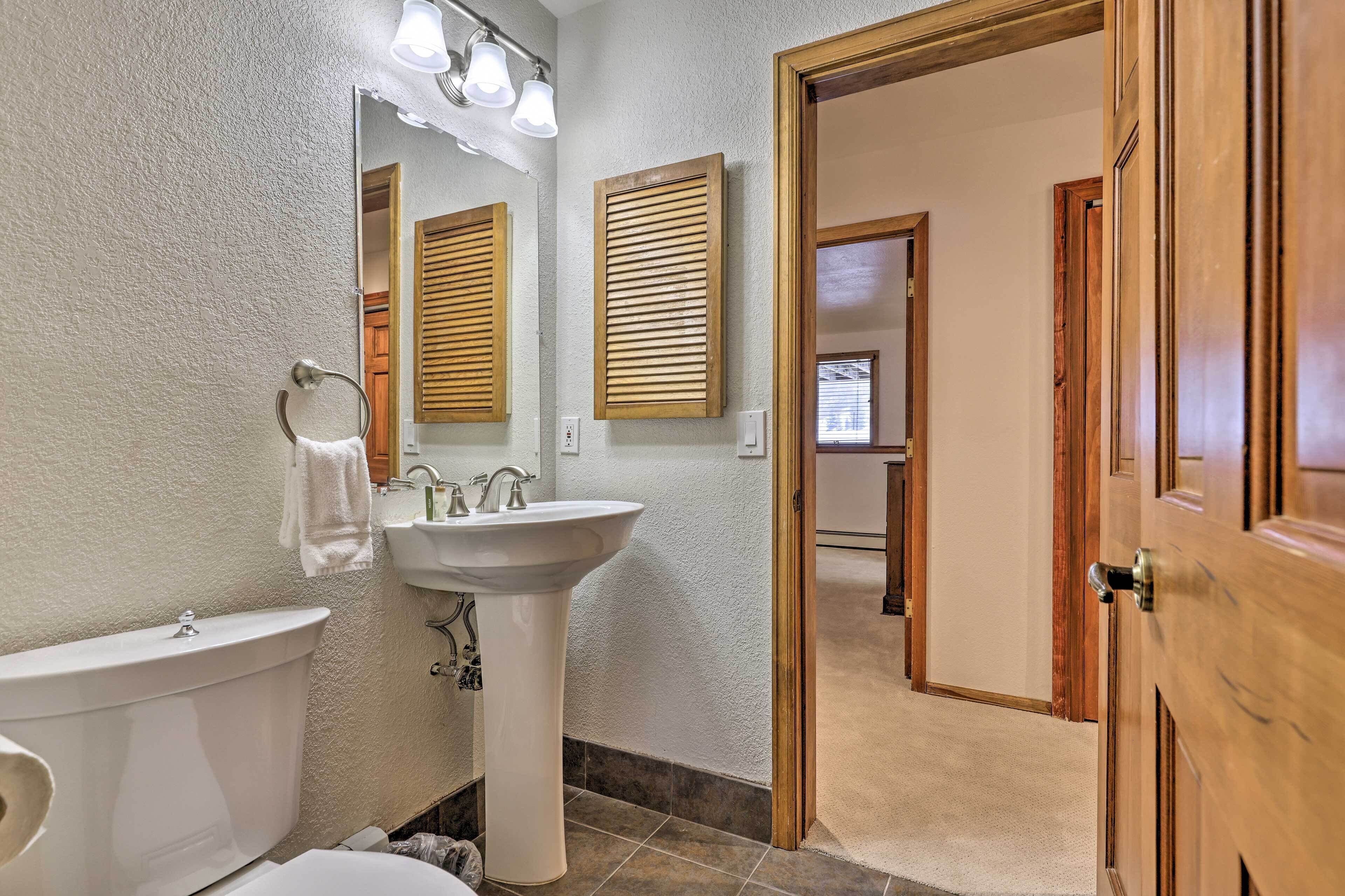 Une salle de bain avec des toilettes, un lavabo et un miroir.