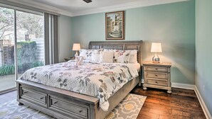 A bedroom with a large bed, two bedside tables, a ceiling fan, and a window with curtains. - Golfers Paradise in Myrtle Beach w/ Balcony! (Myrtle Beach)