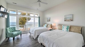 A bedroom with two beds, a chair, and a view of the sea. - Waterfront Scotland Beach Retreat w/ Private Beach (Ridge)