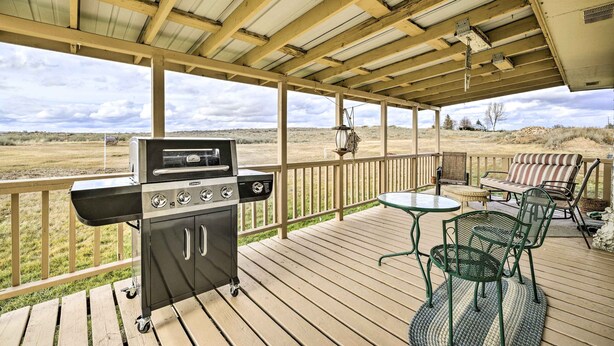 Una terraza cubierta al aire libre con una parrilla, zona de estar y vistas al paisaje.