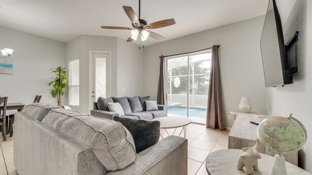 A modern living room with a grey sofa, a coffee table, and a globe on a stand. - Pool & Lanai: Davenport Home 12 Mi to Disney (Davenport)