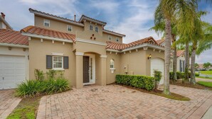 A two-story house with a tiled roof, a garage, and a brick driveway. - Pool & Lanai: Davenport Home 12 Mi to Disney (Davenport)