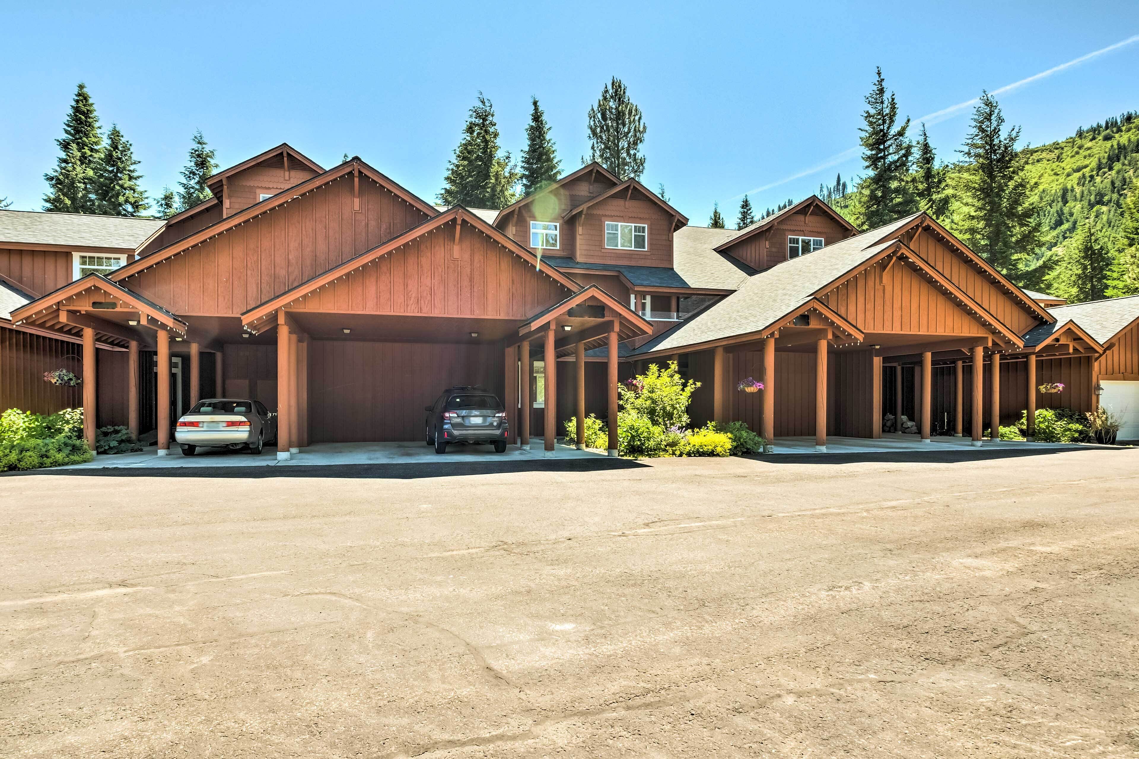 A large wooden lodge with multiple garages and a spacious driveway.