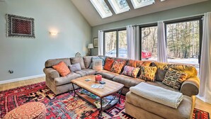 A cozy living room with a sectional sofa, a coffee table, and a patterned rug. - Peaceful Goshen Cottage w/ Screened Porch & Views! (Goshen)