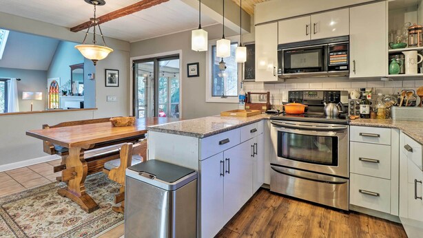 A modern kitchen with stainless steel appliances, wooden accents, and a large island. - Peaceful Goshen Cottage w/ Screened Porch & Views! (Goshen)