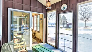 Una habitación con un banco, una silla y vistas al exterior.