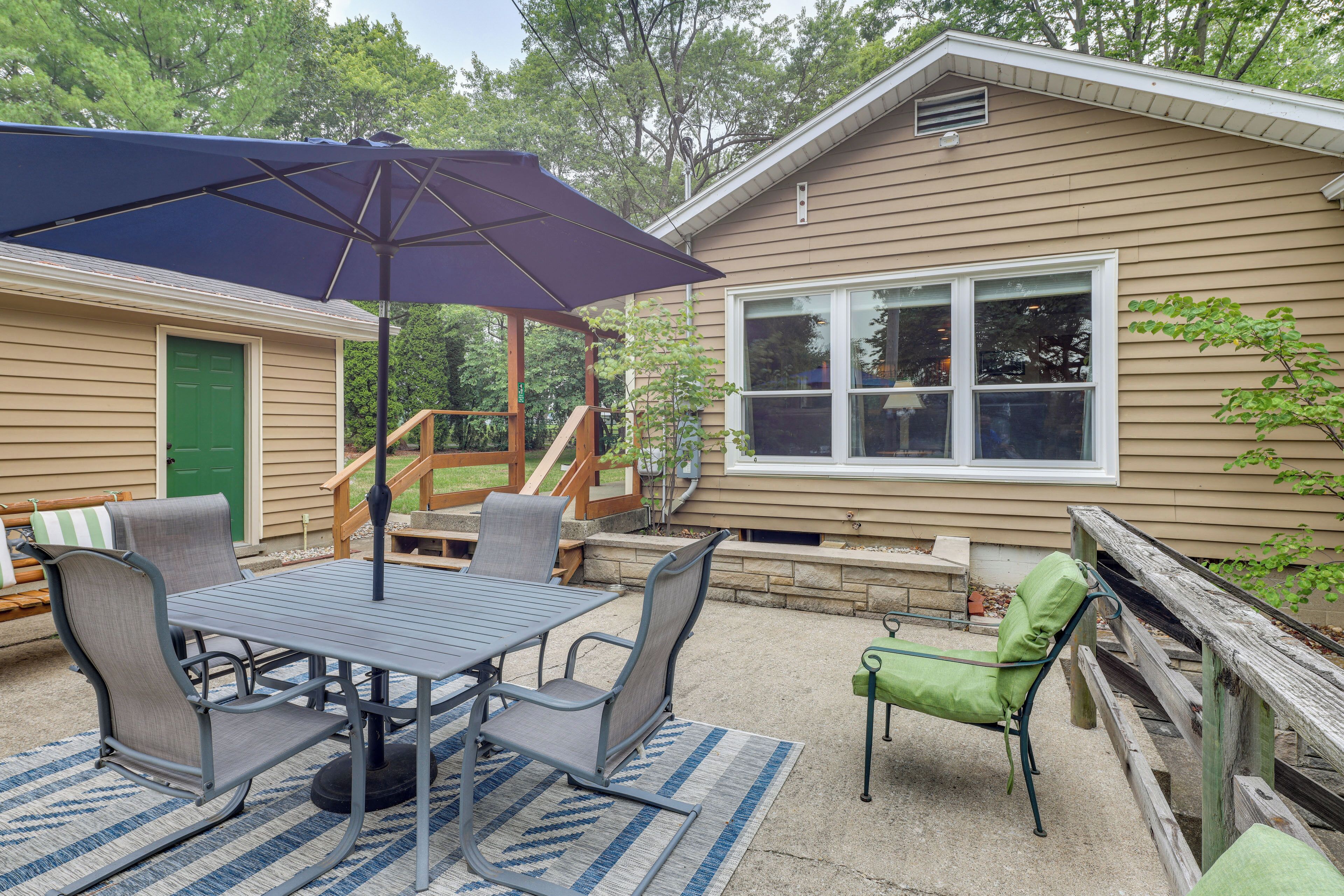 An outdoor patio with a table and chairs, a covered umbrella, and a wooden deck.