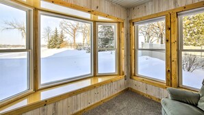 Ein Zimmer mit großen Fenstern, Holzwänden und einem Teppichboden.