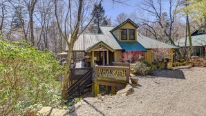 A rustic cabin with a wooden deck and stairs leading to a porch.