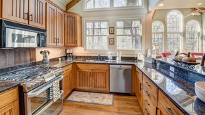 A kitchen with wooden cabinets, a stainless steel stove, and a dishwasher.