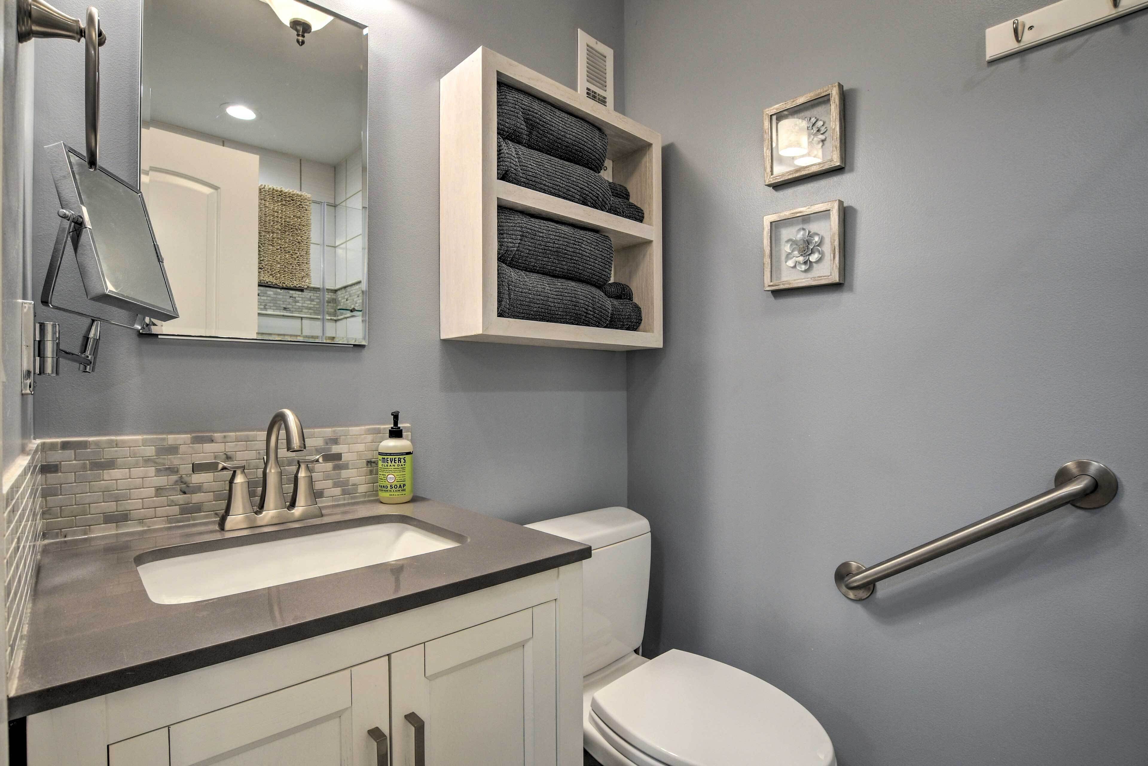 A bathroom with a sink, toilet, and a towel rack.
