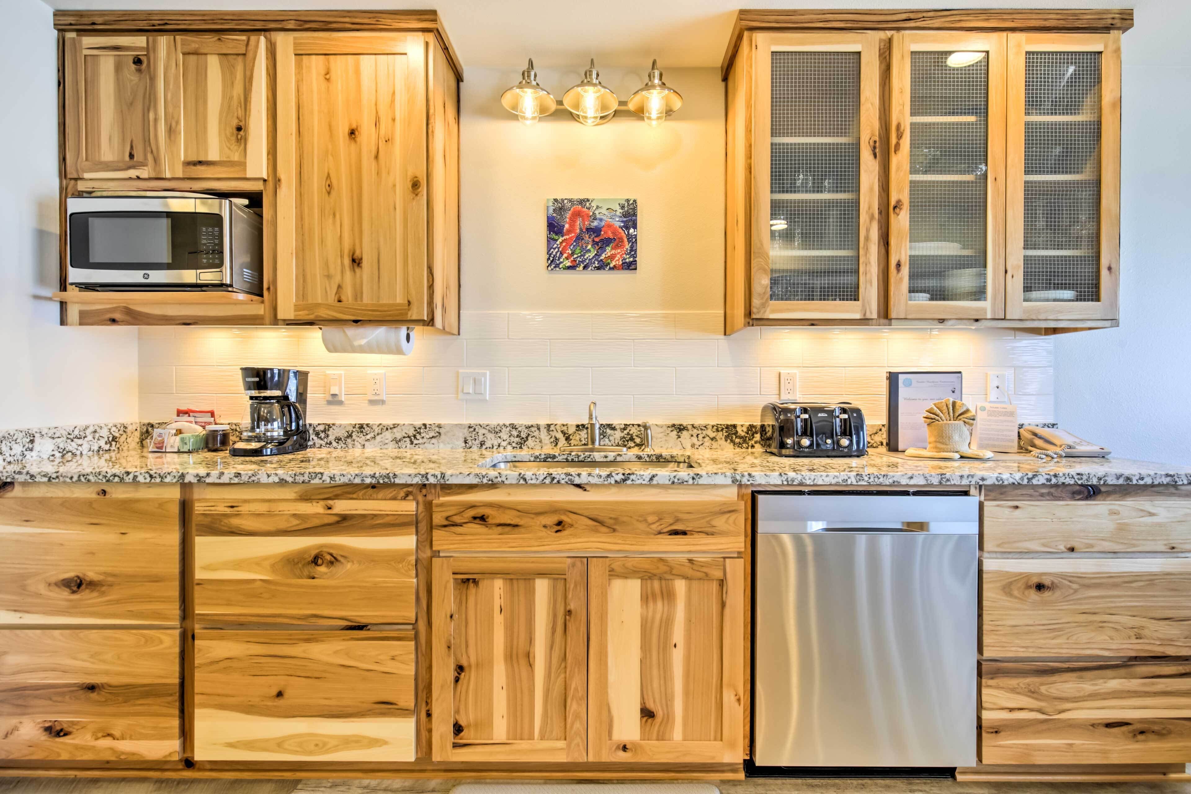 A kitchen with wooden cabinets, a microwave, a coffee maker, and a dishwasher.