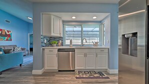 A modern kitchen with white cabinets, a stainless steel dishwasher, and a built-in oven. - Port Richey Getaway w/ Lanai, Pool & Grill! (New Port Richey)