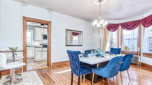 A dining room with a wooden table set for six, blue velvet chairs, and a chandelier. - Front Royal Retreat ~ 1 Mi to National Park! (Front Royal)