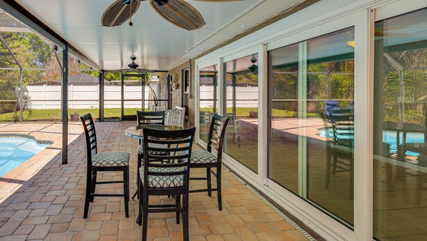 A covered patio with a pool, outdoor seating, and a ceiling fan. - Saltwater Pool! Sebring Oasis Near Lake Jackson (Sebring)