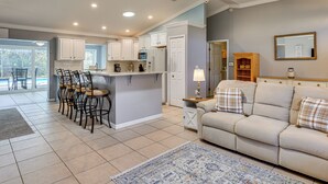 A spacious kitchen with white cabinets, a central island, and a dining area with chairs. - Saltwater Pool! Sebring Oasis Near Lake Jackson (Sebring)