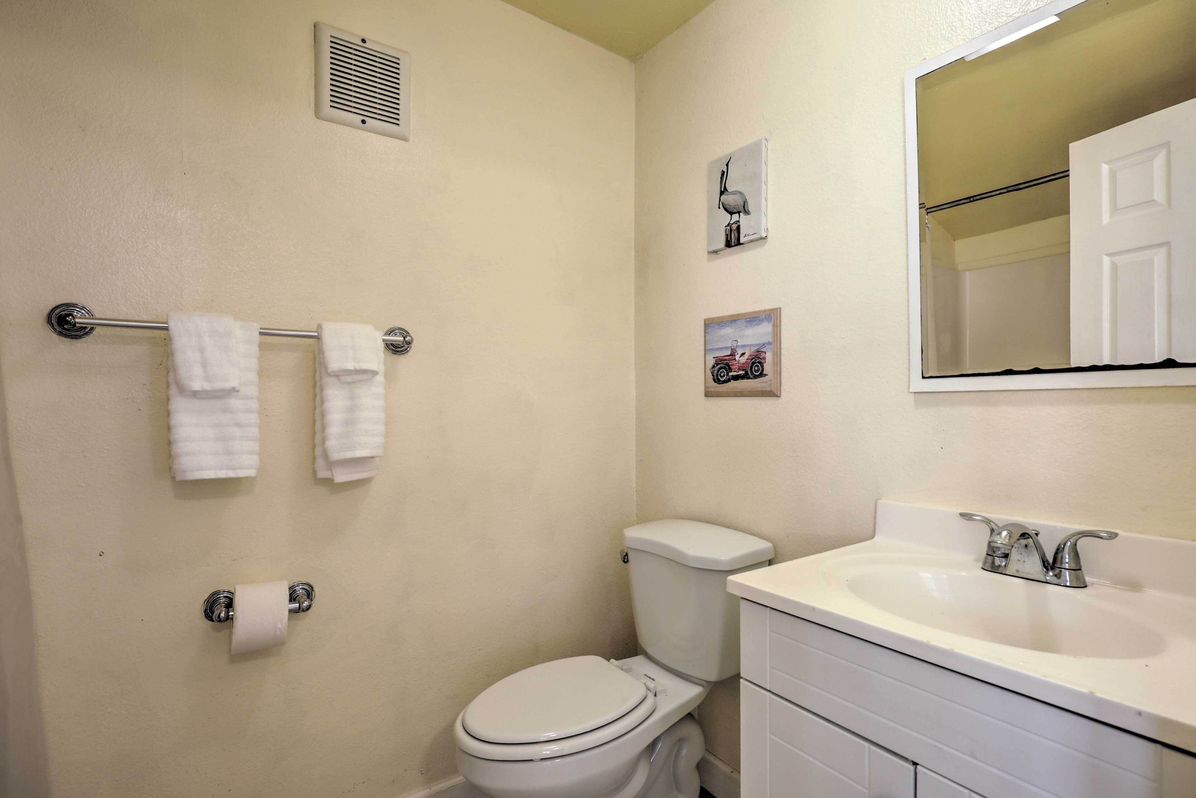 Un baño con inodoro, lavabo y perchero para toallas.