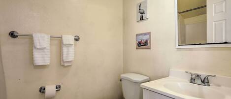 Un baño con inodoro, lavabo y perchero para toallas.