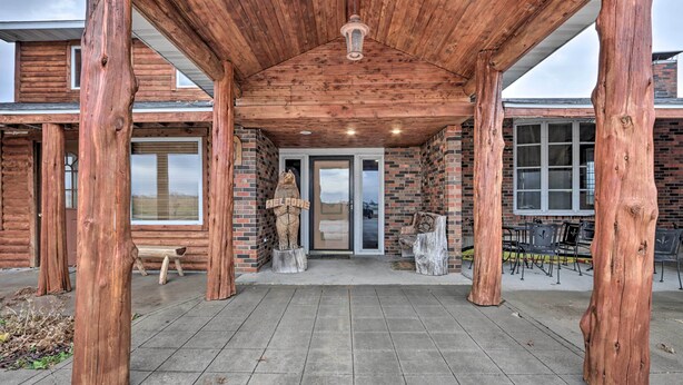 A wooden cabin with a covered patio, a welcome statue, and a brick exterior. - 'wildlife Lodge' Columbia Retreat off I-70! (Fulton)