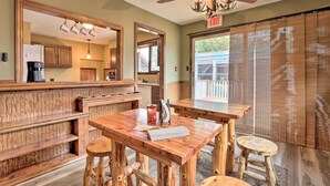 A wooden bar area with a ceiling fan, a large mirror, and a view of the outside through a window with blinds. - 'wildlife Lodge' Columbia Retreat off I-70! (Fulton)
