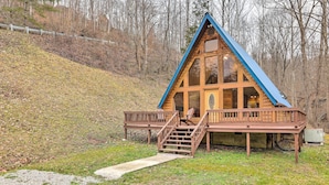 A wooden cabin with a blue roof, a porch, and a staircase leading to the entrance. - Cozy Yatesville Lake Cabin Rental in Louisa! (Louisa)