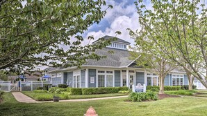 A residential building with a well-maintained lawn, a fire hydrant, and a sign indicating it is a community clubhouse.