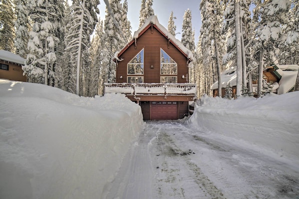 A log cabin with a wooden exterior, a balcony, and a garage door.