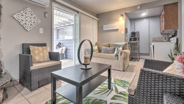 A modern living room with wicker furniture, a dining table, and a kitchen area with cabinets and appliances. - Relaxing Poway Apt w/ Patio Near Parks & Wineries! (Poway)