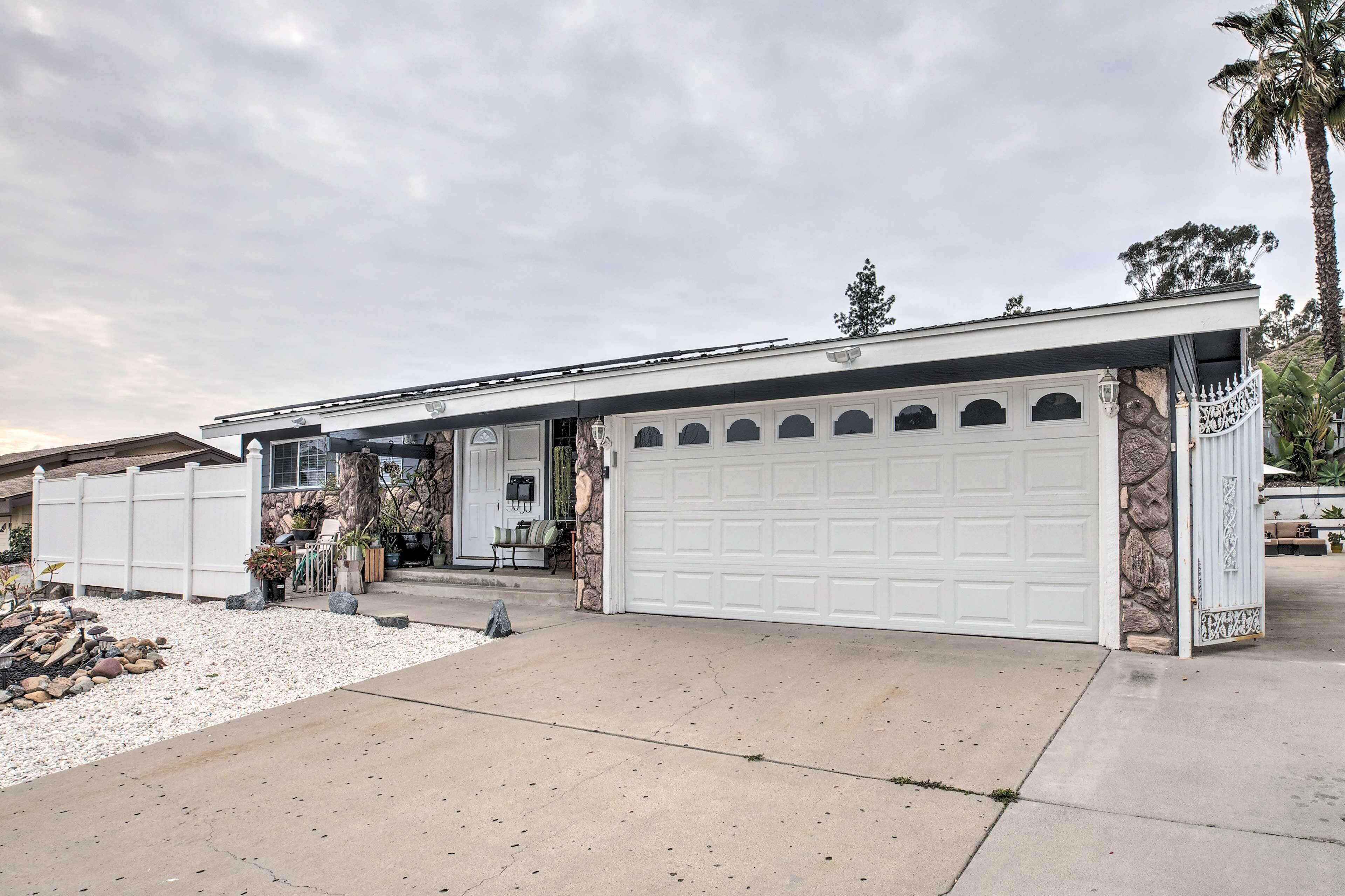 A single-story house with a garage, a front porch with outdoor seating, and a stone accent wall.