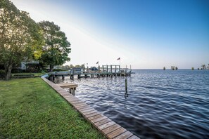 A wooden dock extending into calm water, surrounded by lush greenery and a clear sky. - Waterfront Edenton Bay Cottage - Walk to Dtwn (Edenton)