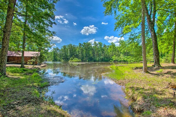 A serene lakeside setting with a wooden cabin and lush greenery.