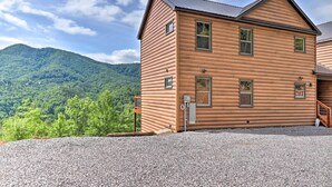 A log cabin with a gravel driveway and a mountain backdrop. - Mountain Dew Cabin w/ Hot Tub & Scenic Views! (Sevierville)