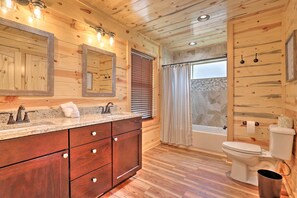 A wooden cabin bathroom with a wooden vanity, two sinks, a toilet, and a bathtub. - Mountain Dew Cabin w/ Hot Tub & Scenic Views! (Sevierville)