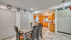 A dining area with a checkered table, wooden chairs, and a kitchen in the background. - 'the Shady Cottage' < 1 Mi to Downtown Millersburg (Millersburg)