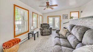 A living room with a gray sofa, a recliner, a ceiling fan, and large windows with blinds. - 'the Shady Cottage' < 1 Mi to Downtown Millersburg (Millersburg)