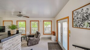 A living room with a fireplace, a ceiling fan, a sofa, a coffee table, and a door leading to a balcony. - 'the Shady Cottage' < 1 Mi to Downtown Millersburg (Millersburg)
